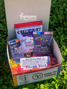 a box filled with lots of candy sitting on top of some green grass and bushes