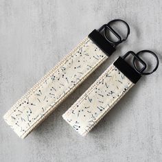 two straps with black buckles on each side and an off - white background