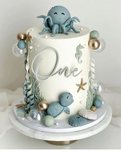 a one tiered cake decorated with an octopus and other sea creatures is on a plate