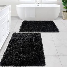 two black rugs in front of a bathtub and sink