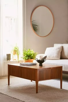 a living room with a couch, coffee table and potted plants