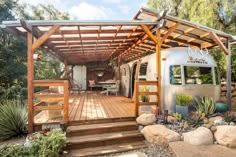 an airstream sits in the middle of a garden with rocks and succulents