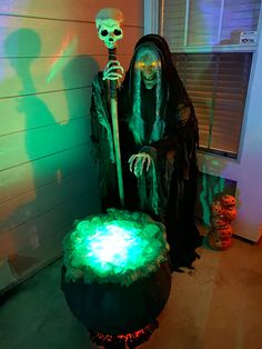 a skeleton sitting on top of a chair in front of a window with green light