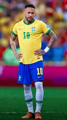 a soccer player standing on the field with his hands on his hips