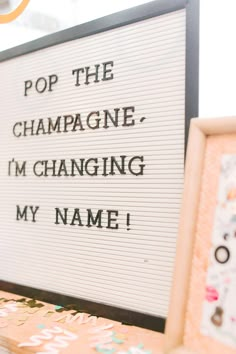 a sign that says pop the champagne, i'm changing my name on it