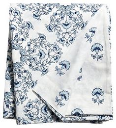 two blue and white floral napkins on top of each other, one folded up