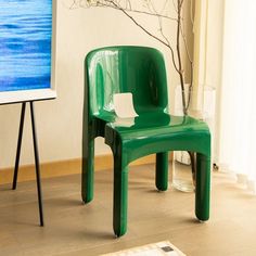 a green plastic chair sitting in front of a tv