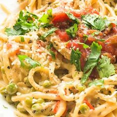 a plate of pasta with meat and vegetables on it, garnished with parsley