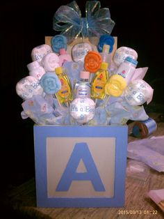 a blue box filled with baby items on top of a wooden table in front of a black background