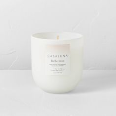 a white candle sitting on top of a table