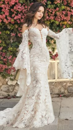 a woman in a white wedding dress standing outside