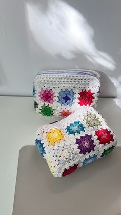 two crocheted purses sitting on top of a table