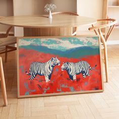 a painting of two white tigers on a red and blue background in front of a wooden table