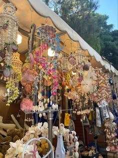 an outdoor market with lots of items for sale on the shelves and hanging from the ceiling