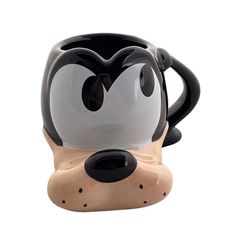 a black and white coffee mug with a goofy face on it's front end