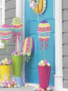 colorful easter decorations on the front door of a house with balloons and eggs in buckets