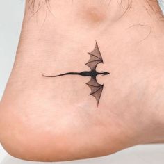 a woman's foot with a small tattoo design on the side of her leg