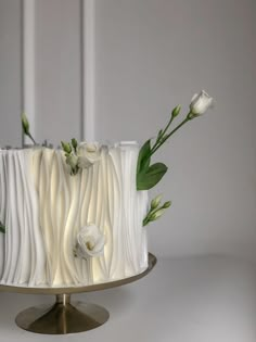 a cake with white frosting and flowers on top