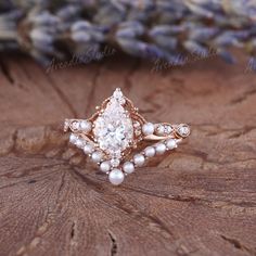 a close up of a ring on a wooden surface with lavender flowers in the background