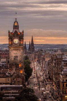 a clock tower towering over a city filled with tall buildings