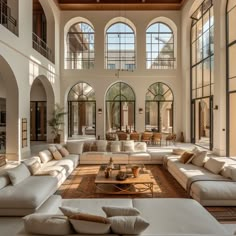 a large living room with lots of windows and couches in it's center