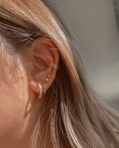 a close up of a person with ear piercings on their ears and behind them is a woman's head