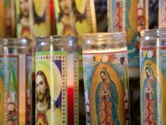 many candles with pictures of jesus on them