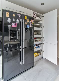 a kitchen with an icebox, refrigerator and shelves filled with magnets on the doors