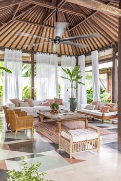 a living room filled with lots of furniture and plants on top of a checkered floor