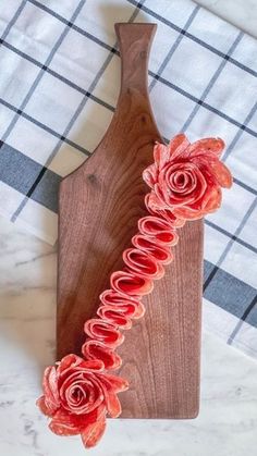 a wooden cutting board with flowers on it