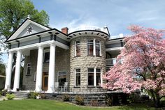 a large stone house with white columns on the front