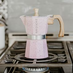 a pink stove top with a coffee pot on it