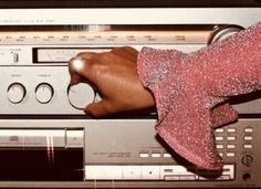 a person's hand on top of an old stereo receiver with other electronic equipment in the background