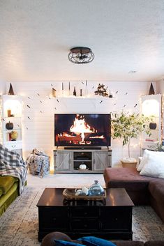 a living room filled with furniture and a fire place in the middle of the room