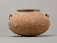 an old clay vase is shown against a gray background