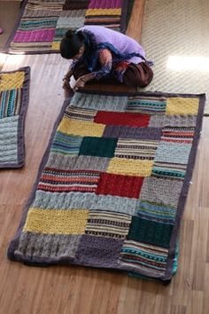 a person laying on top of a multicolored rug