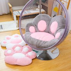 a pink and grey chair sitting on top of a wooden floor next to a mirror