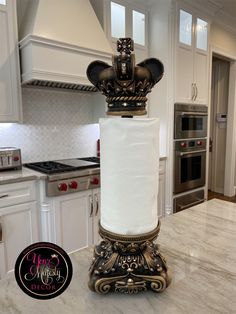 a roll of toilet paper sitting on top of a stand in the middle of a kitchen