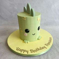 a birthday cake with a green cupcake on top