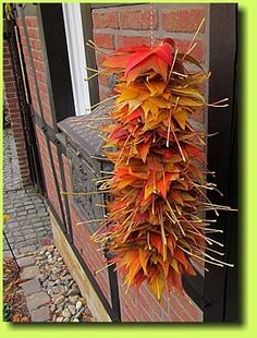 an orange and yellow plant hanging from the side of a brick building next to a door