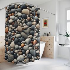 a shower curtain with rocks on it in a white room next to a bathtub