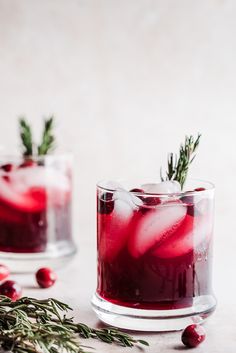 two glasses filled with cranberry punch and garnished with rosemary