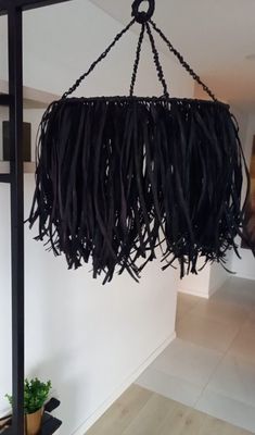 a black piece of art hanging from a ceiling