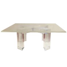 a glass table with three legs and two ends