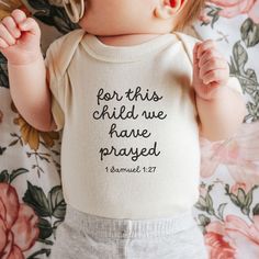 a baby laying on top of a bed wearing a shirt with the words fear this child we have passed