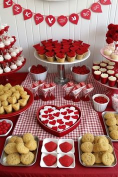 valentine's day dessert table with heart shaped cookies and cupcakes