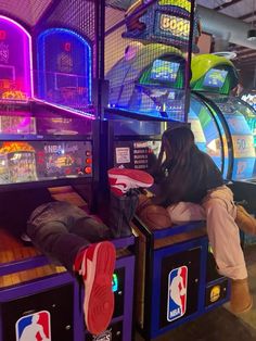 a man laying on top of a machine in a room filled with basketball hoops