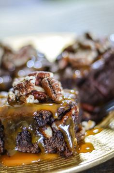 a piece of chocolate cake with caramel sauce and pecans