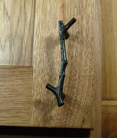 a black handle on a wooden cabinet door