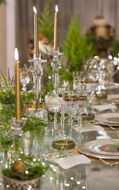 the table is set with silverware and greenery for an elegant holiday dinner or special occasion